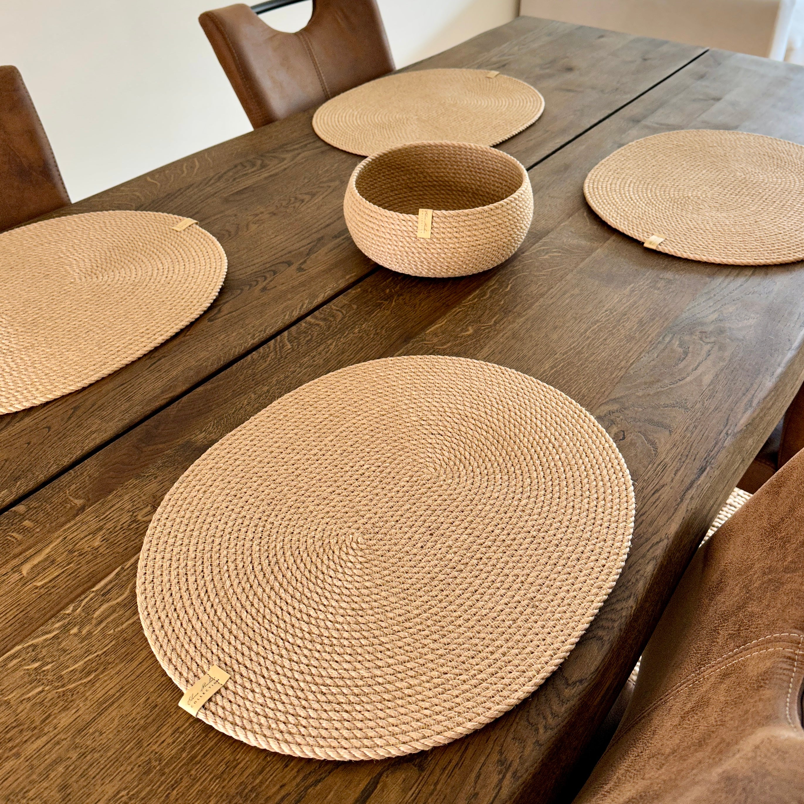 Øko-sæt til hjemmet: fire ovale dækkeservietter i jute 45×35 cm og en rund tøndeformet kurv 20×10 cm. Den gyldne nuance af jute giver hygge til både festlig og daglig borddækning.