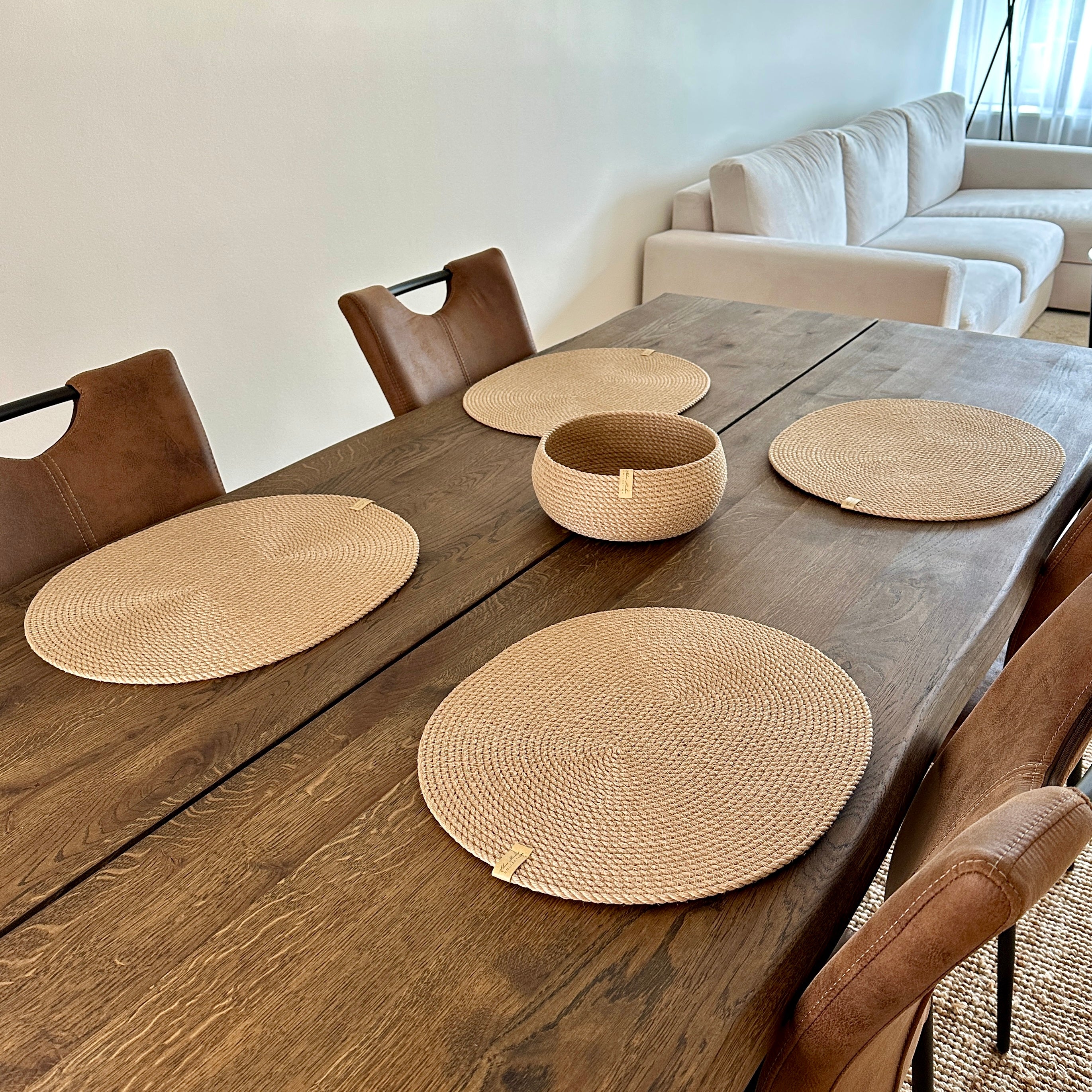 Håndlavet jutesæt: fire ovale dækkeservietter 45×35 cm og en rund tøndeformet kurv 20×10 cm. Naturlige materialer, holdbar kvalitet og skandinavisk æstetik.