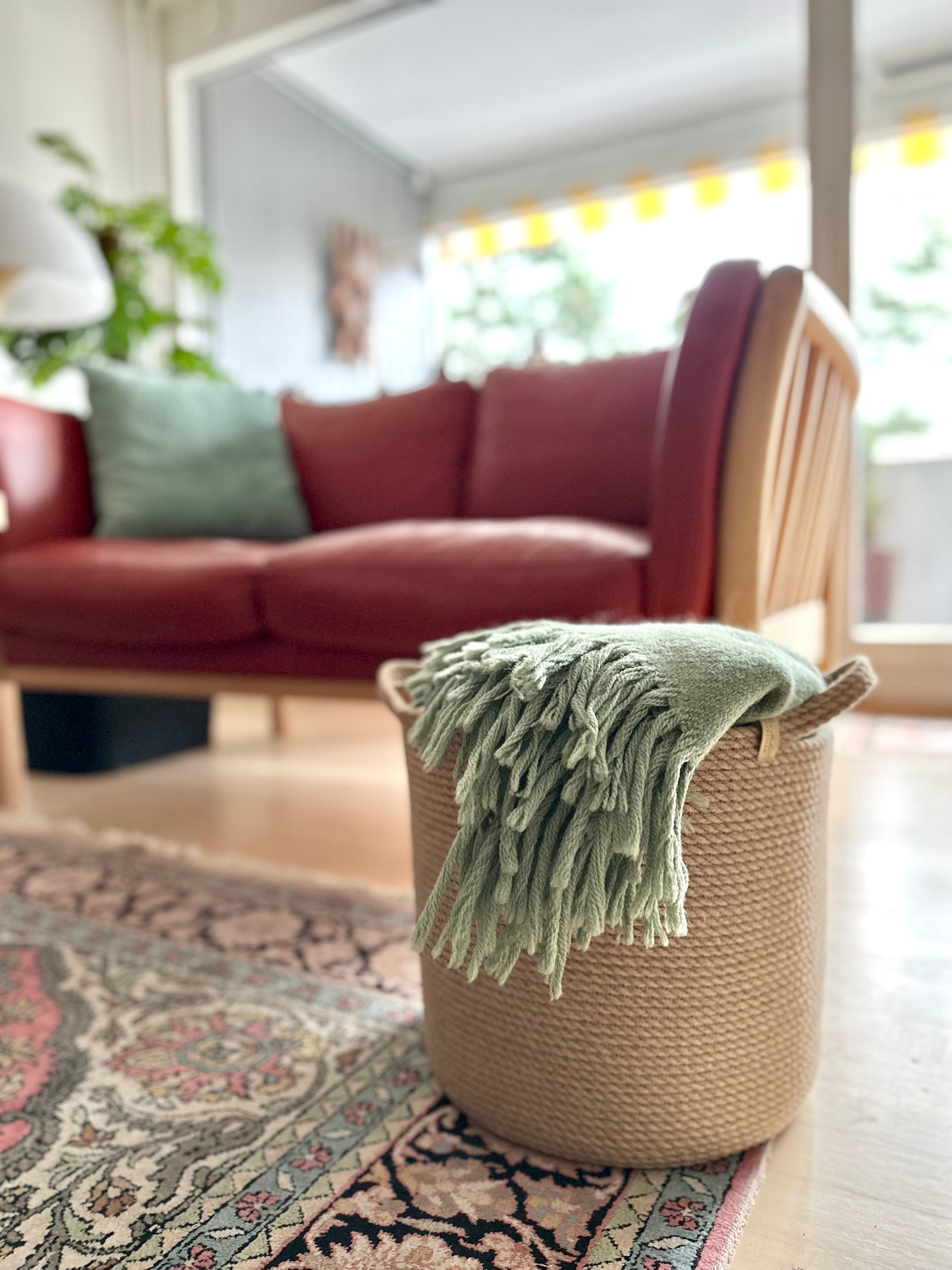 Naturlig jute kurv i cylindrisk form med praktiske håndtag, håndlavet, stærk og miljøvenlig. Perfekt til opbevaring af tekstiler, puder eller andre ting i hjemmet.