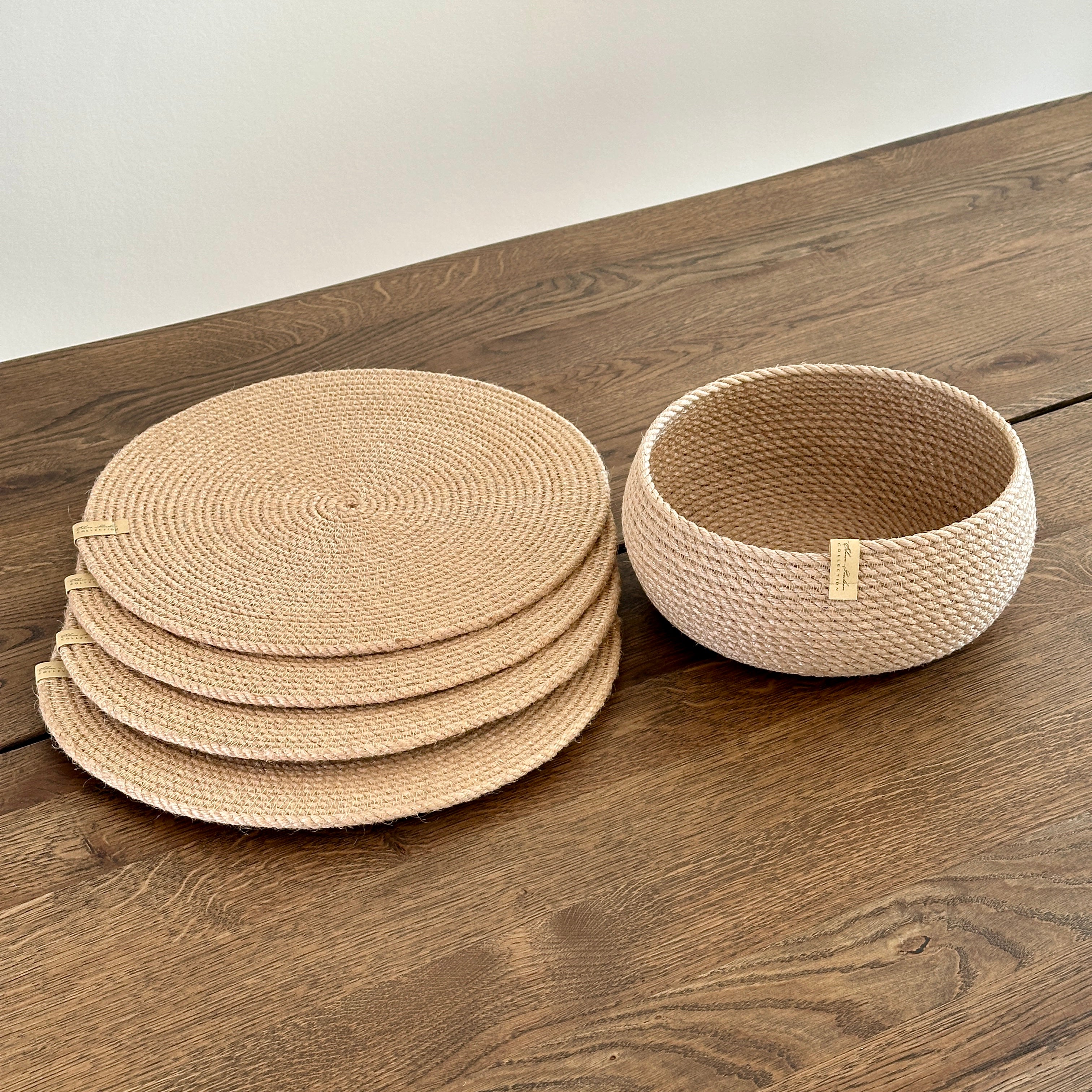 Serveringssæt: fire runde dækkeservietter af naturjute Ø33 cm samt en tøndeformet kurv 20×10 cm. Håndlavet i bæredygtige materialer med gylden jute.