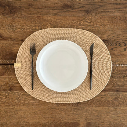 Oval håndlavet jutedækkeserviet, holdbar og bæredygtig, perfekt til borddækning og beskyttelse af bordet.