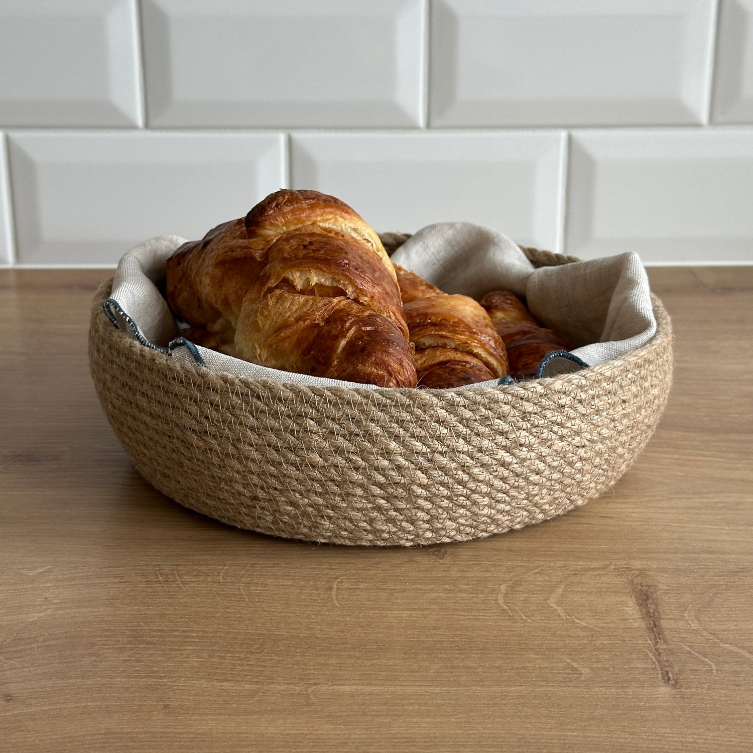 Rund kurv af holdbar jute, miljøvenlig og stilfuld, til servering af bagværk.