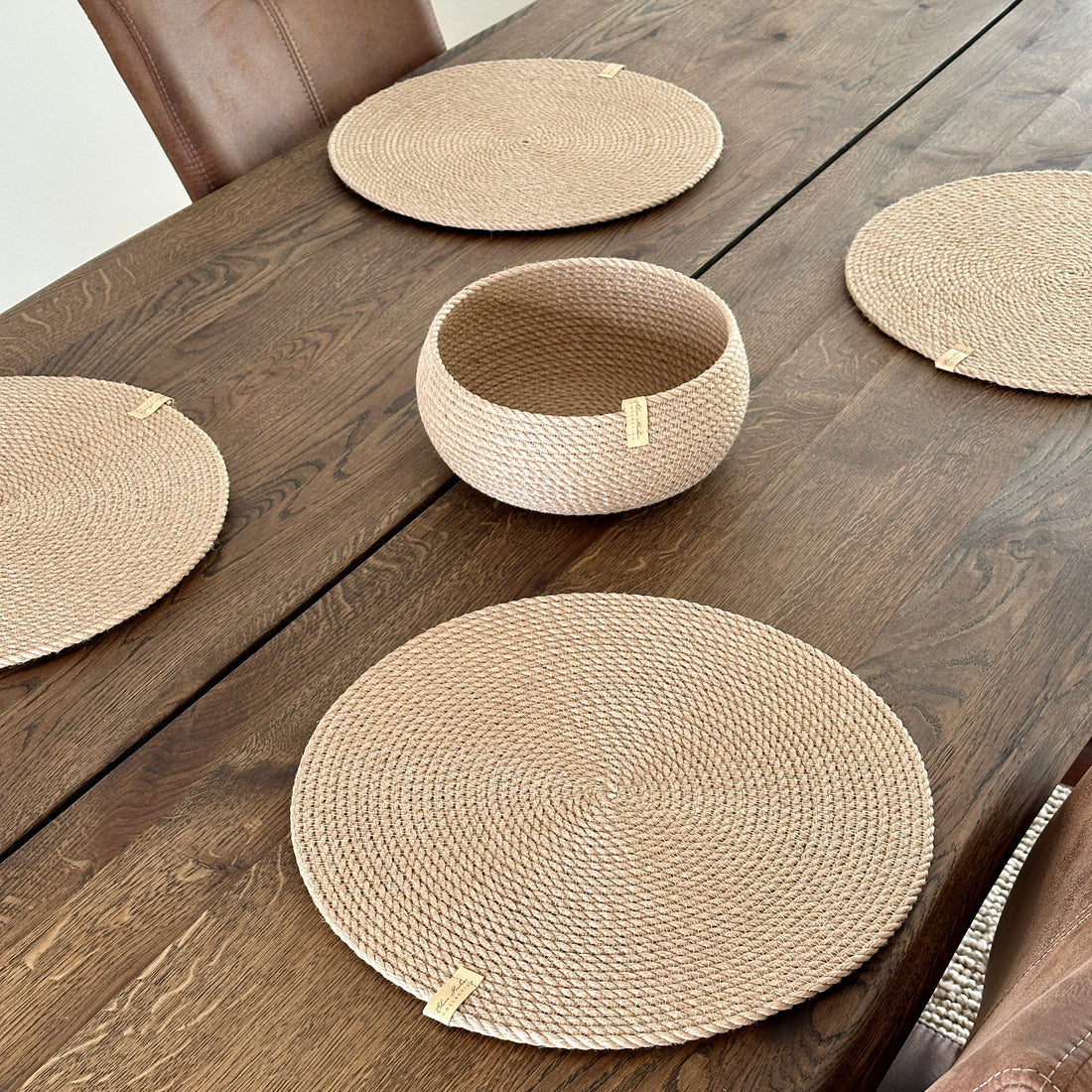 Øko-sæt: fire runde dækkeservietter i jute Ø37 cm og en rund tøndeformet kurv 20×10 cm. Naturlig struktur, premiumkvalitet, perfekt til stilfuld borddækning.