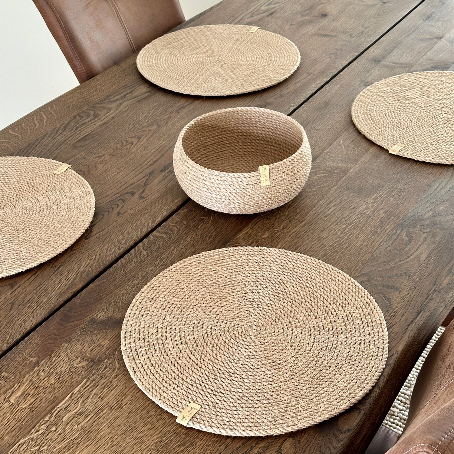 Øko-sæt: fire runde dækkeservietter i jute Ø37 cm og en rund tøndeformet kurv 20×10 cm. Naturlig struktur, premiumkvalitet, perfekt til stilfuld borddækning.