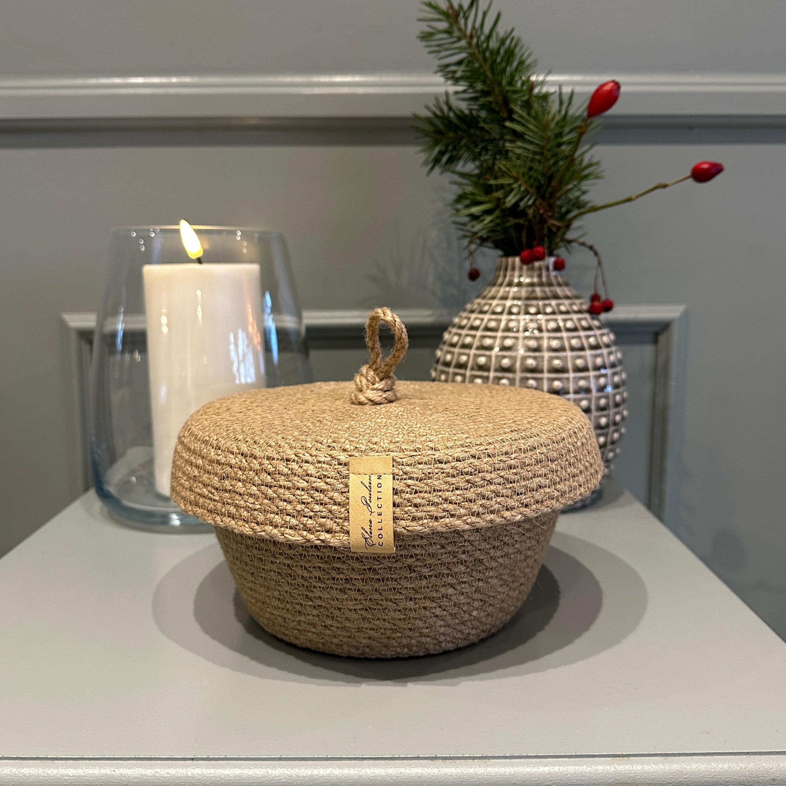 Elegant jutekurv med låg, håndlavet af naturmateriale. Bæredygtigt og stilfuldt interiørtilbehør, ideelt som gave.