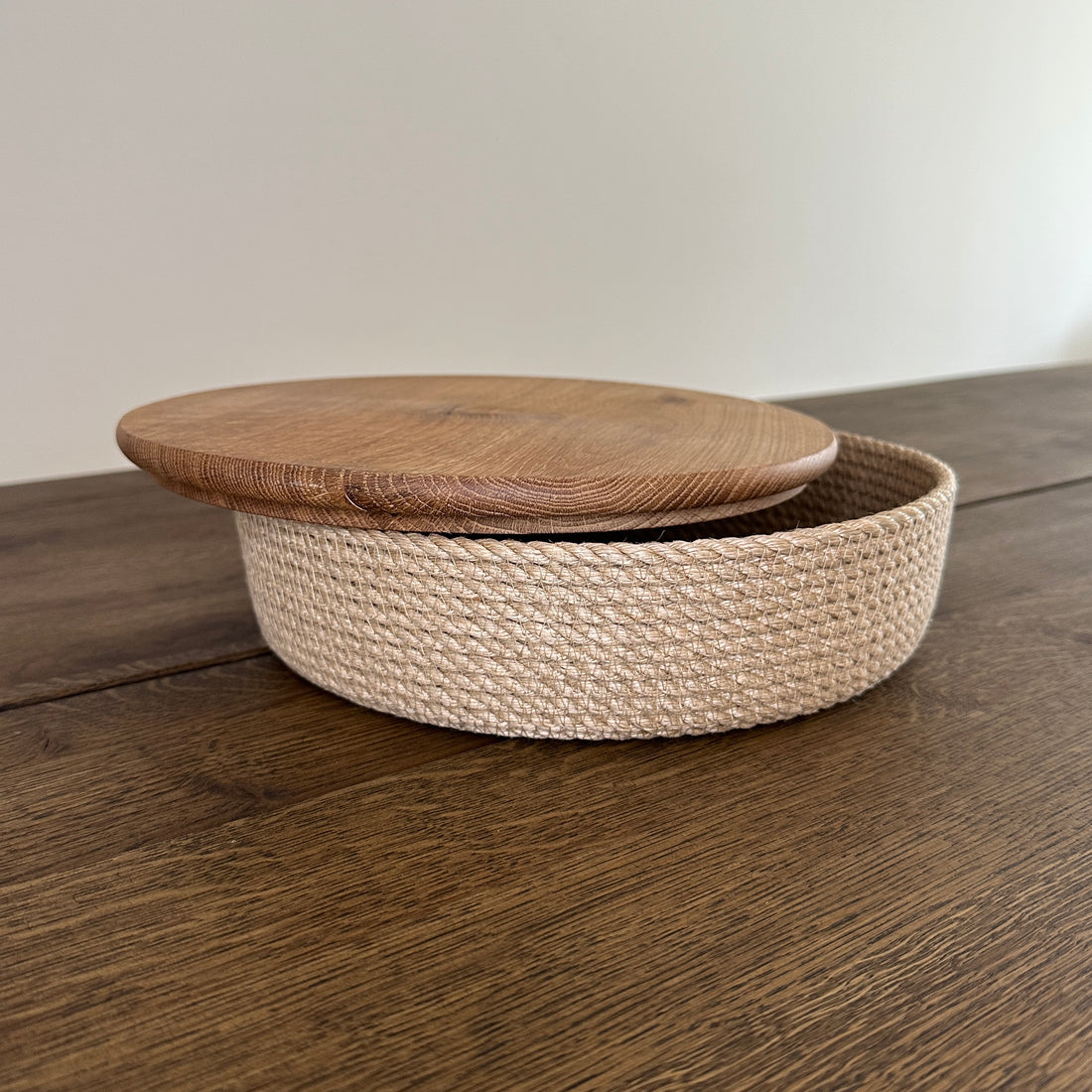 Rund kurv af jute med låg i massivt egetræ. Velegnet til servering af brød, ost eller frugt.