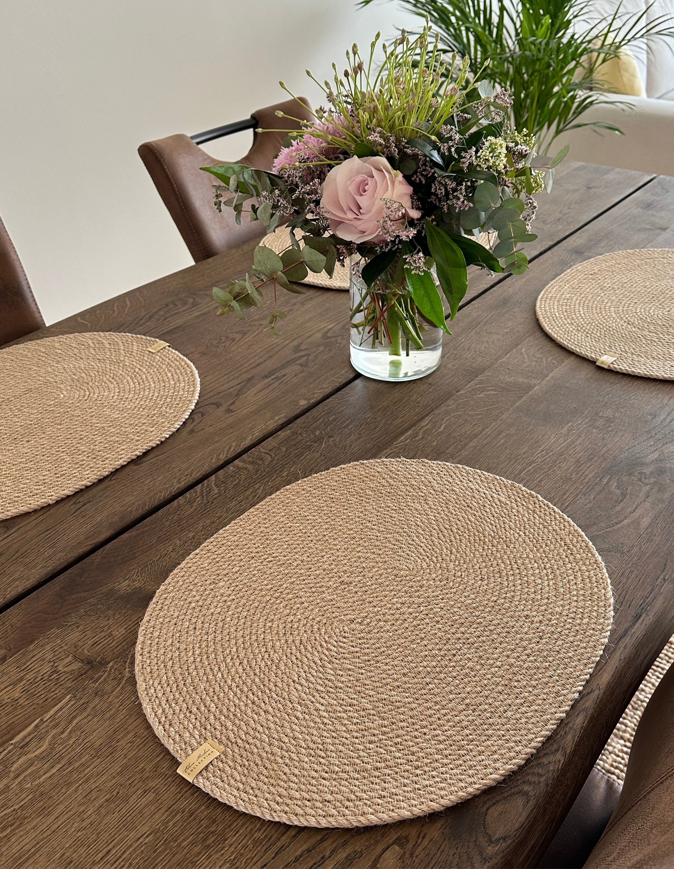 Sæt af ovale håndlavede jutedækkeservietter til bæredygtig og æstetisk borddækning.