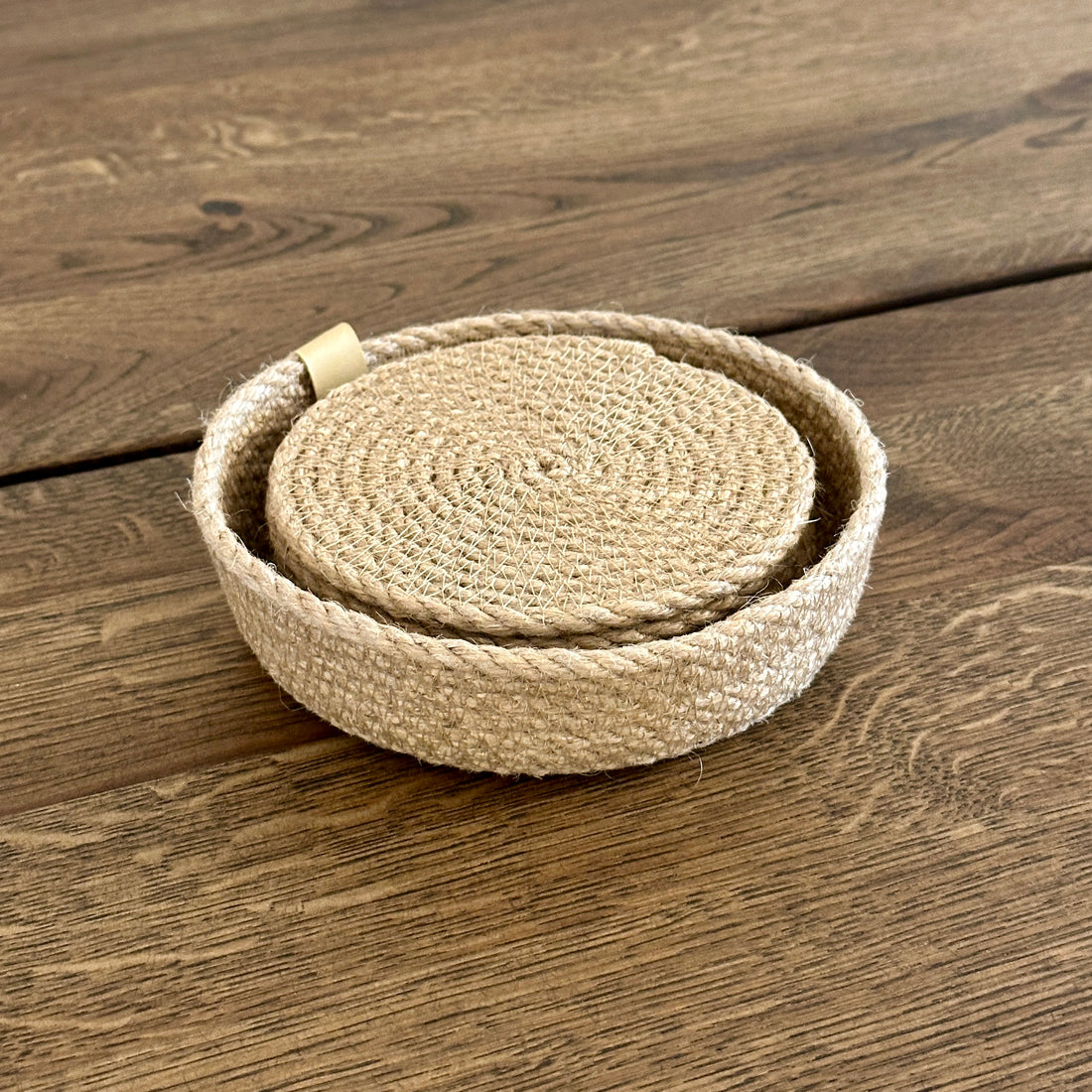 Sæt med seks glasbrikker i premium jute (Ø11 cm) i en lille kurv — håndlavet i høj kvalitet. Et varmt, naturligt indslag i indretningen, der beskytter bordet mod varme kopper, ridser og pletter.