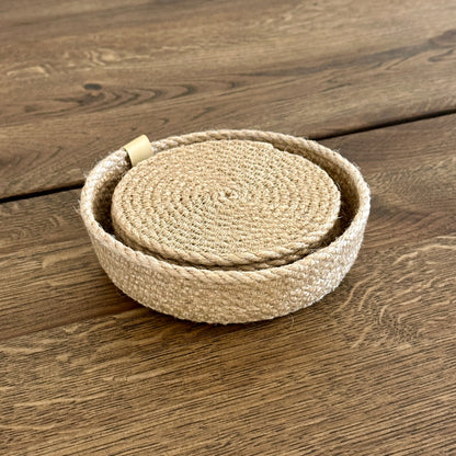 Sæt med seks glasbrikker i premium jute (Ø11 cm) i en lille kurv — håndlavet i høj kvalitet. Et varmt, naturligt indslag i indretningen, der beskytter bordet mod varme kopper, ridser og pletter.