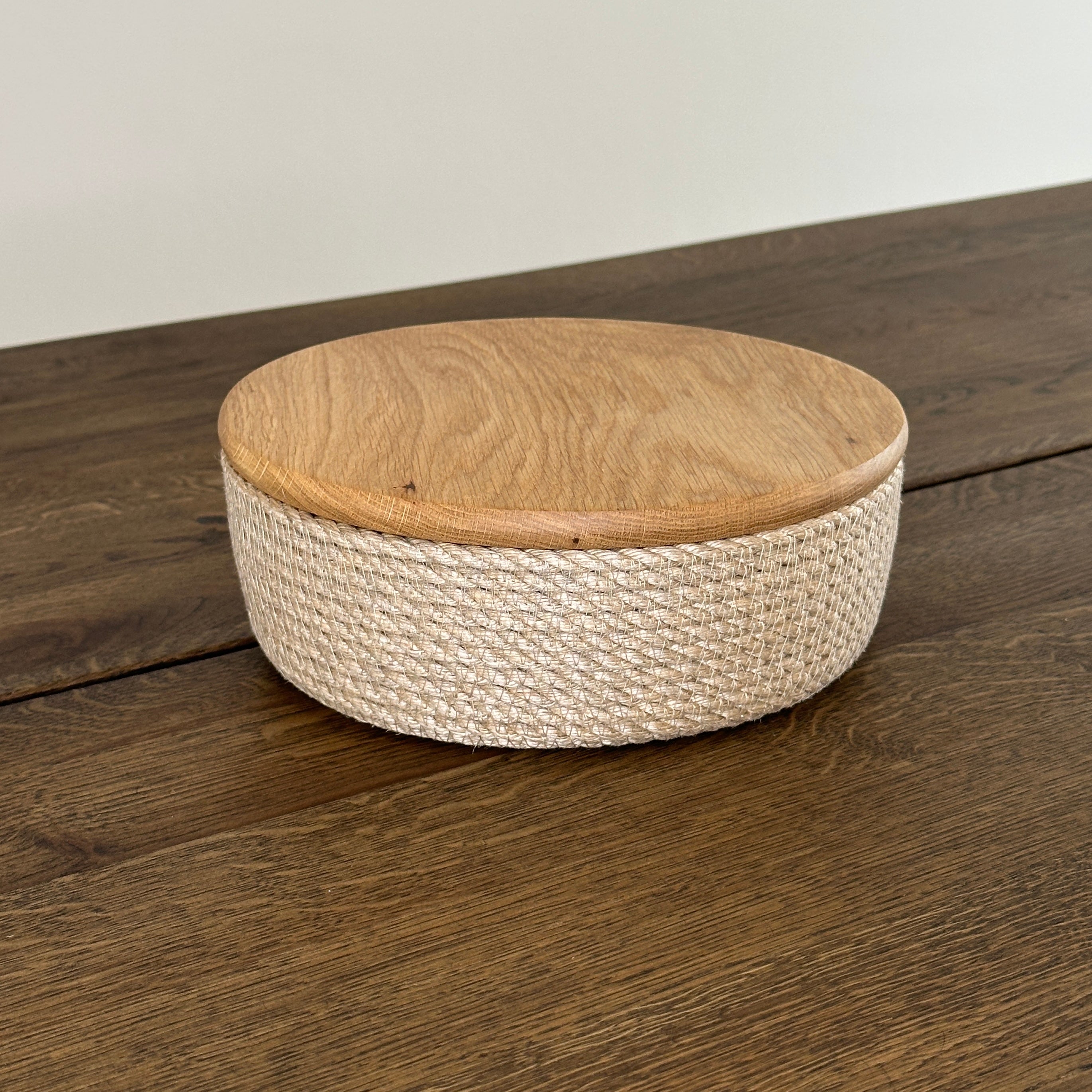 Lav rund kurv af jute med låg i eg. Perfekt til servering af brød, ost eller frugt.