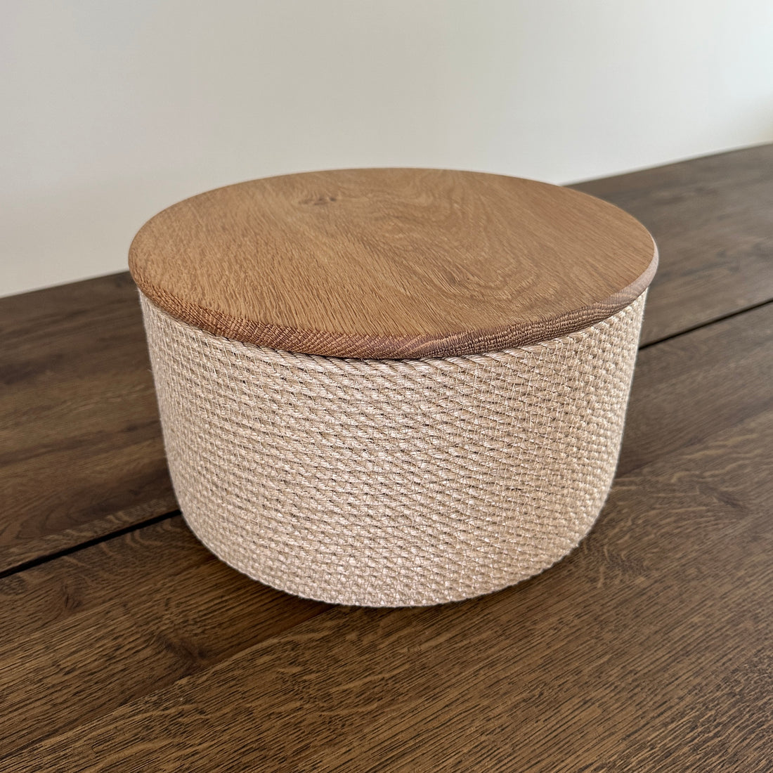 Rund håndlavet kurv af jute med låg i massivt egetræ. Et bæredygtigt og stilfuldt valg til opbevaring og servering.