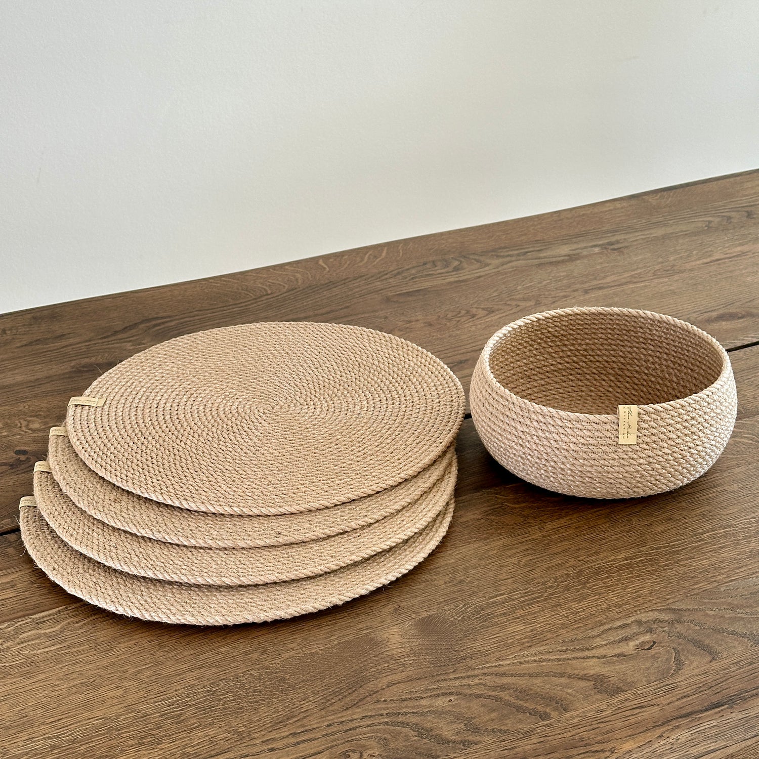 Serveringssæt: fire runde dækkeservietter af jute Ø37 cm samt en tøndeformet kurv 20×10 cm. Håndlavet i bæredygtige materialer med gylden jute.