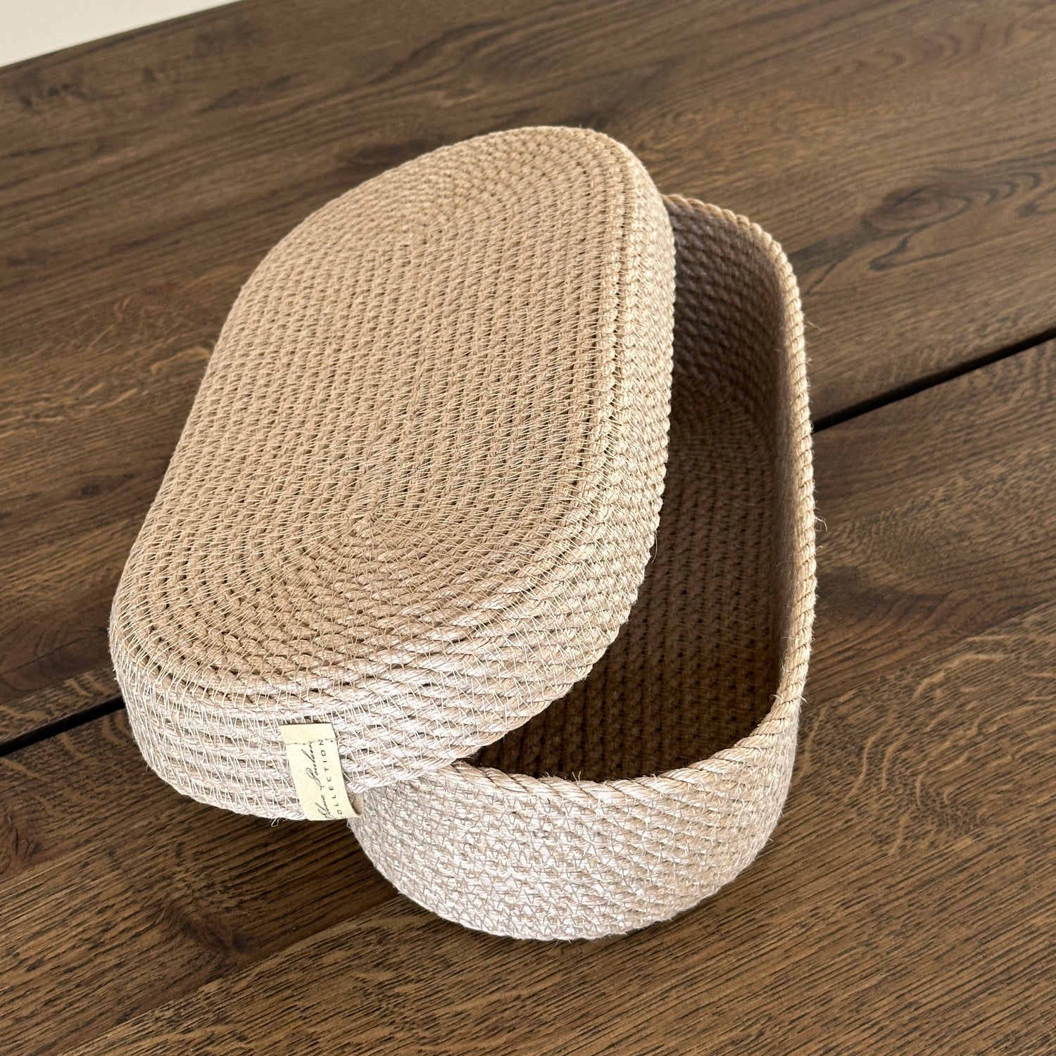 Kurv i oval form af naturjute med låg. Et alsidigt produkt i høj kvalitet til opbevaring og borddækning, perfekt til brød og bestik.