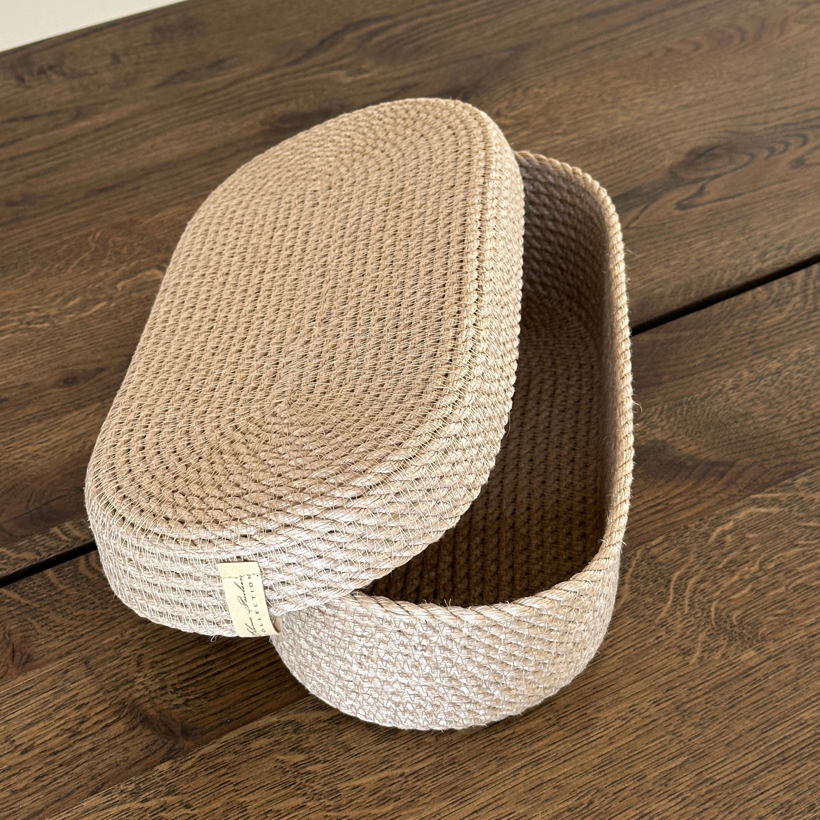 Kurv i oval form af naturjute med låg. Et alsidigt produkt i høj kvalitet til opbevaring og borddækning, perfekt til brød og bestik.