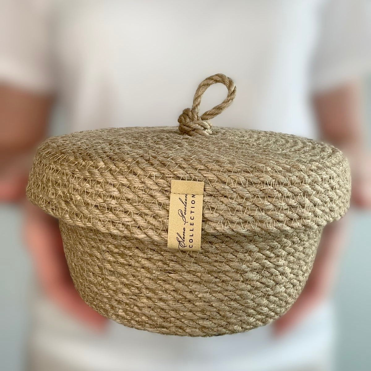 Håndlavet jutekurv med låg og løkke, fremstillet af naturmaterialer. Holdbar og bæredygtig løsning til opbevaring, perfekt som gave.