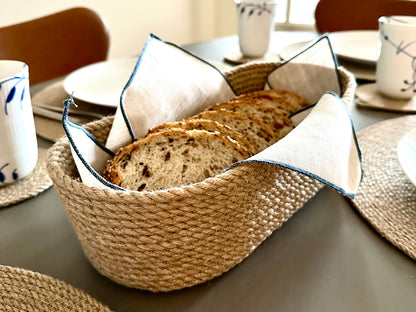 Oval håndlavet kurv af jute, praktisk til servering og opbevaring af bagværk, frugt eller småting.