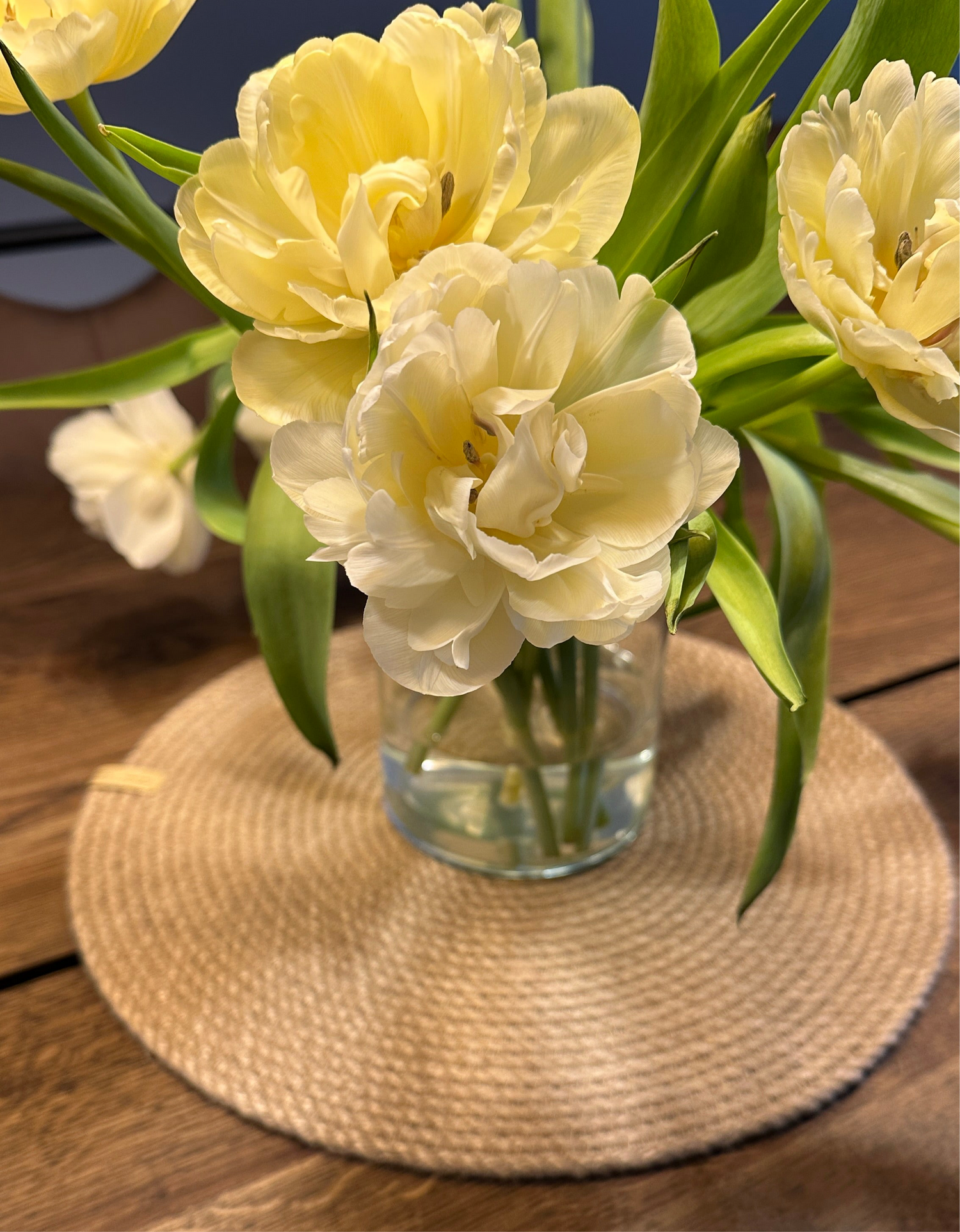 Rund håndlavet jutedækkeserviet som base for borddækning, bæredygtig dekoration til spisebordet.