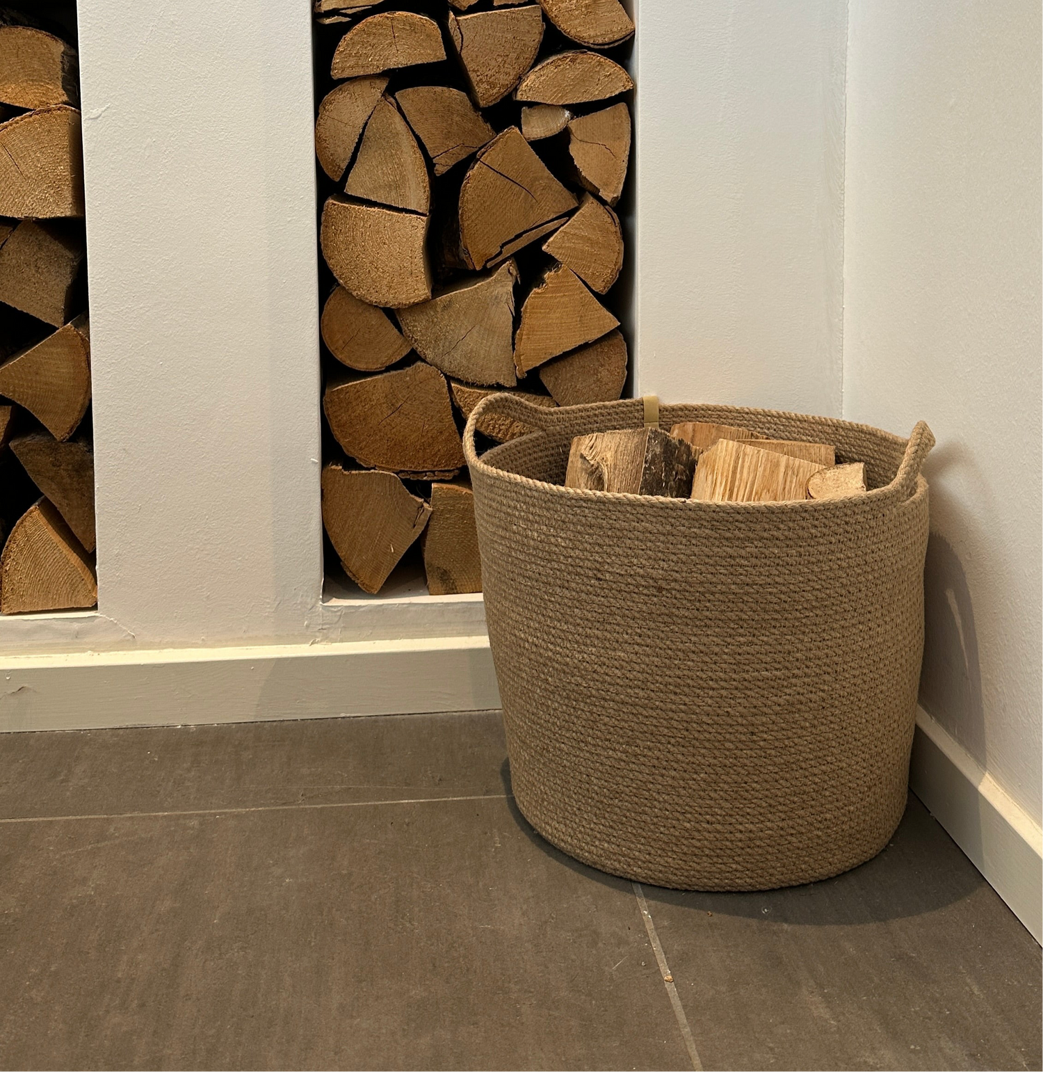Håndlavet jutekurv med praktiske håndtag – et bæredygtigt og dekorativt valg til opbevaring af brænde ved pejsen.