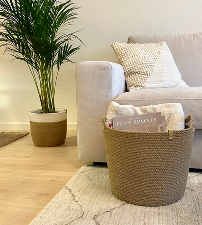 Rund kurv af naturlig jute med håndtag, håndlavet, holdbar og miljøvenlig. Ideel til opbevaring af plaider, puder og magasiner i stuen.