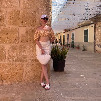 Universel lille taske i mælkefarvet bomuld, perfekt til sommerens look.