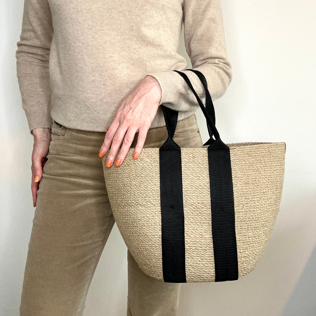 Håndlavet taske af naturlig jute med stærke sorte hanke. Et stilfuldt og praktisk valg til hverdagsbrug.