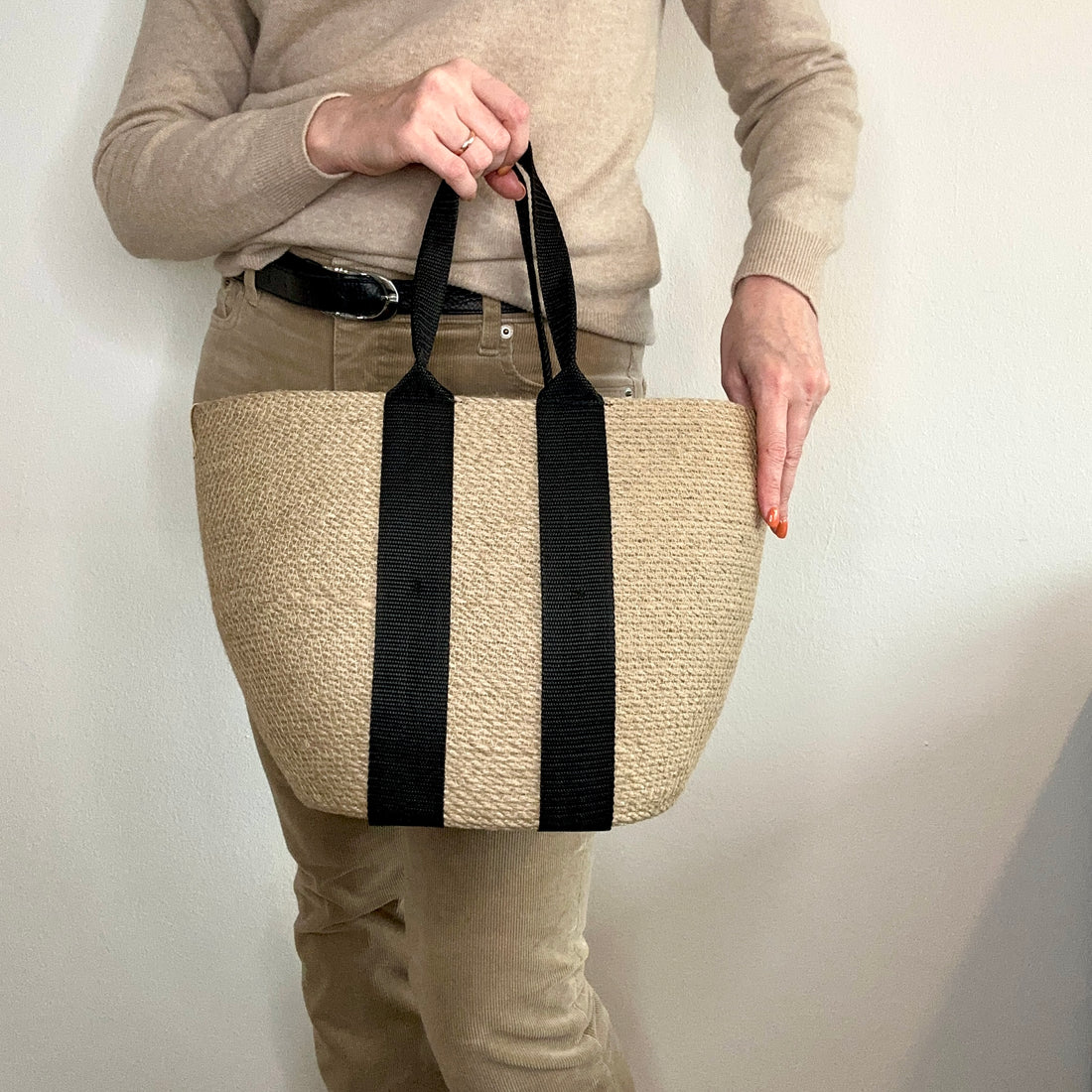 Rummelig jute-taske med lange sorte stropper, perfekt til shopping eller ture. Et bæredygtigt og holdbart tilbehør.