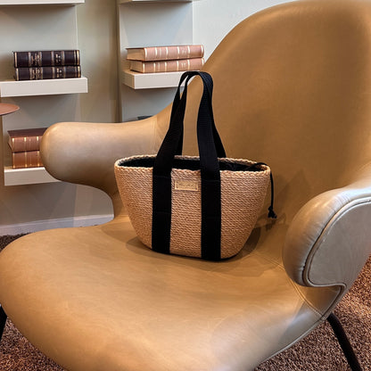 Stilfuld håndlavet jute-taske med sorte tekstilhanke og indvendig pose med snøre til sikker opbevaring.