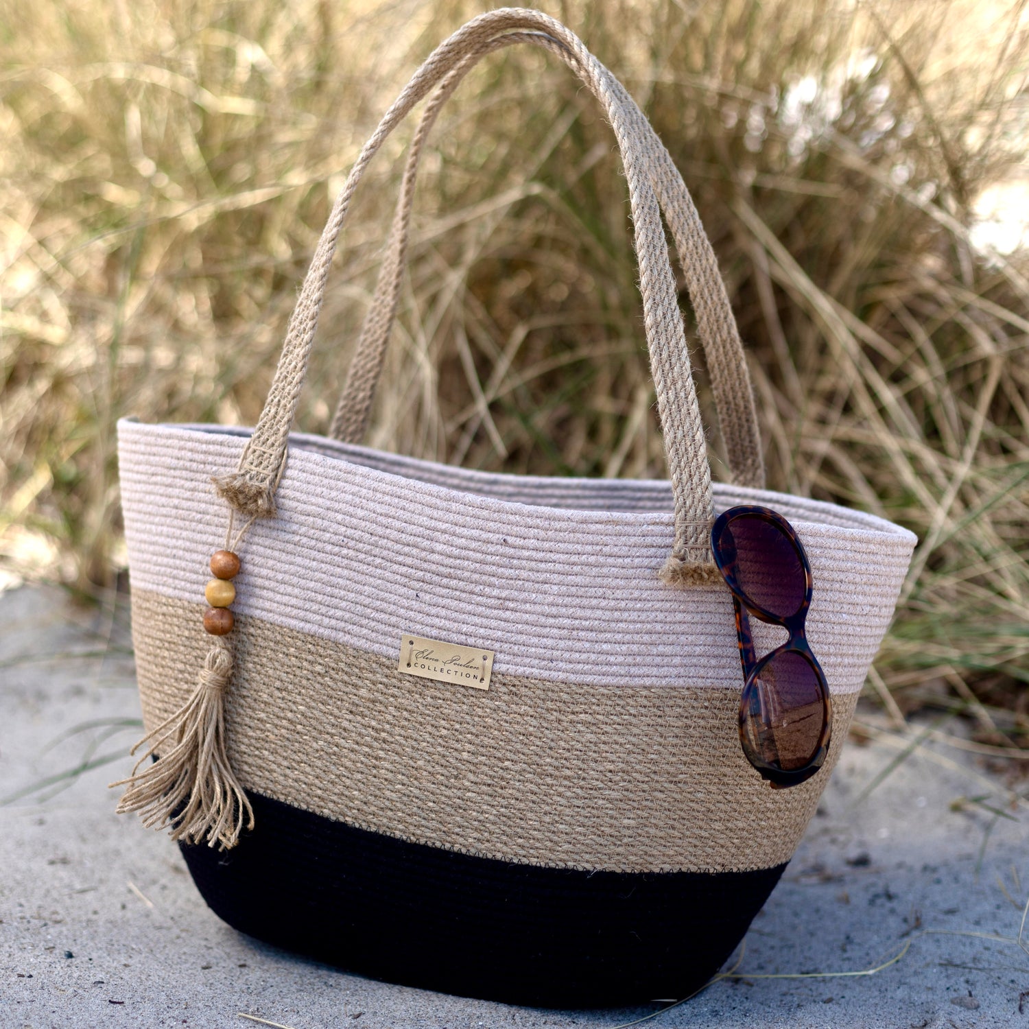 Stor og rummelig taske af jute og bomuldssnor med stærke hanke og kvast med trædetaljer. Et naturligt og holdbart håndlavet tilbehør.