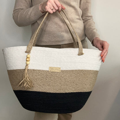 Elegant taske af naturmaterialer – jute og bomuld. Lange hanke og kvast med perler giver modellen et særligt udtryk.