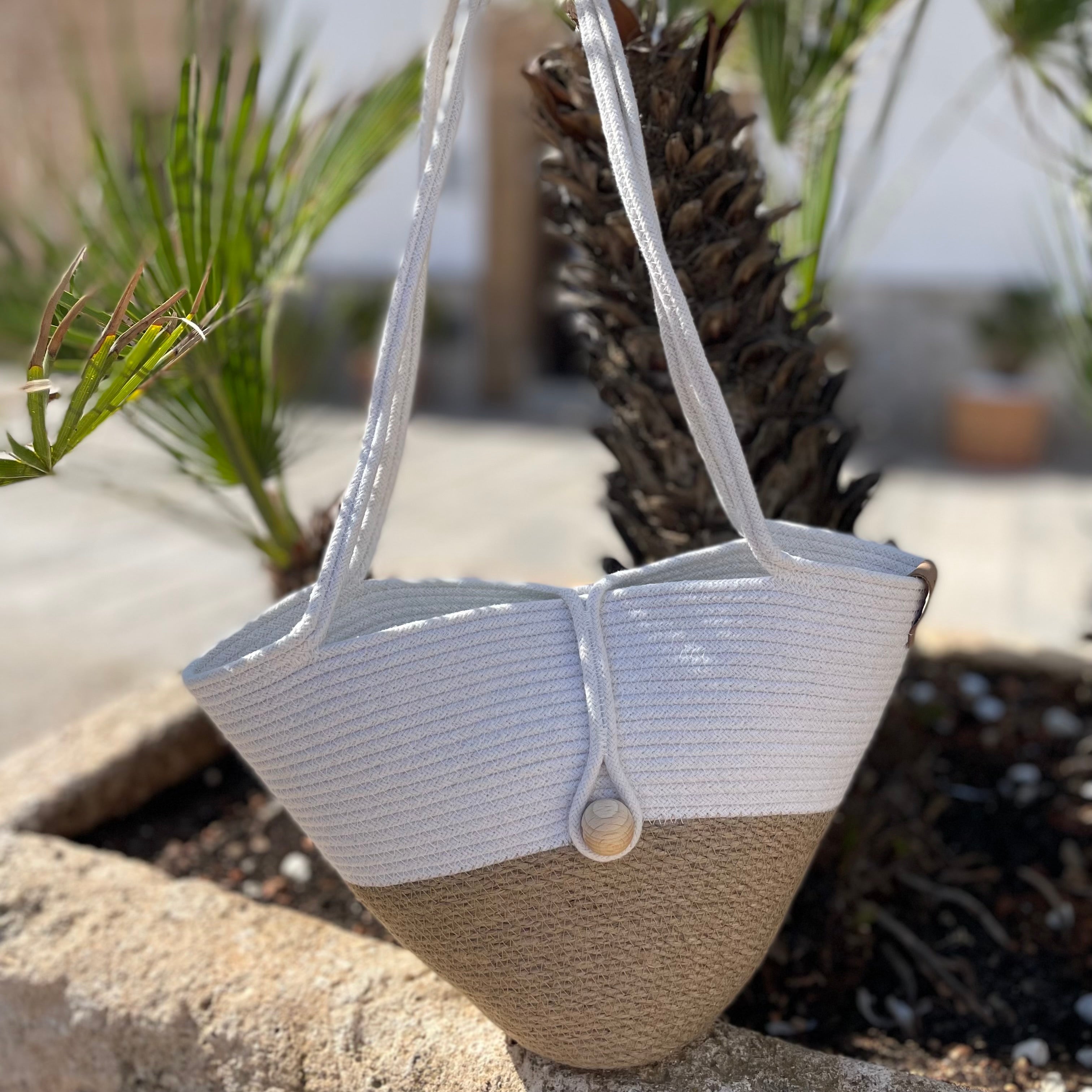 Håndlavet taske af jute og bomuldssnor med lange hanke og lukning med trækugle. Et let og stilfuldt accessory.
