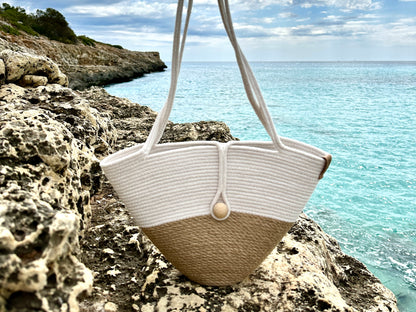 Lille tofarvet håndlavet taske med lange hanke og lukning med trækugle. Et universelt valg til by og fritid.