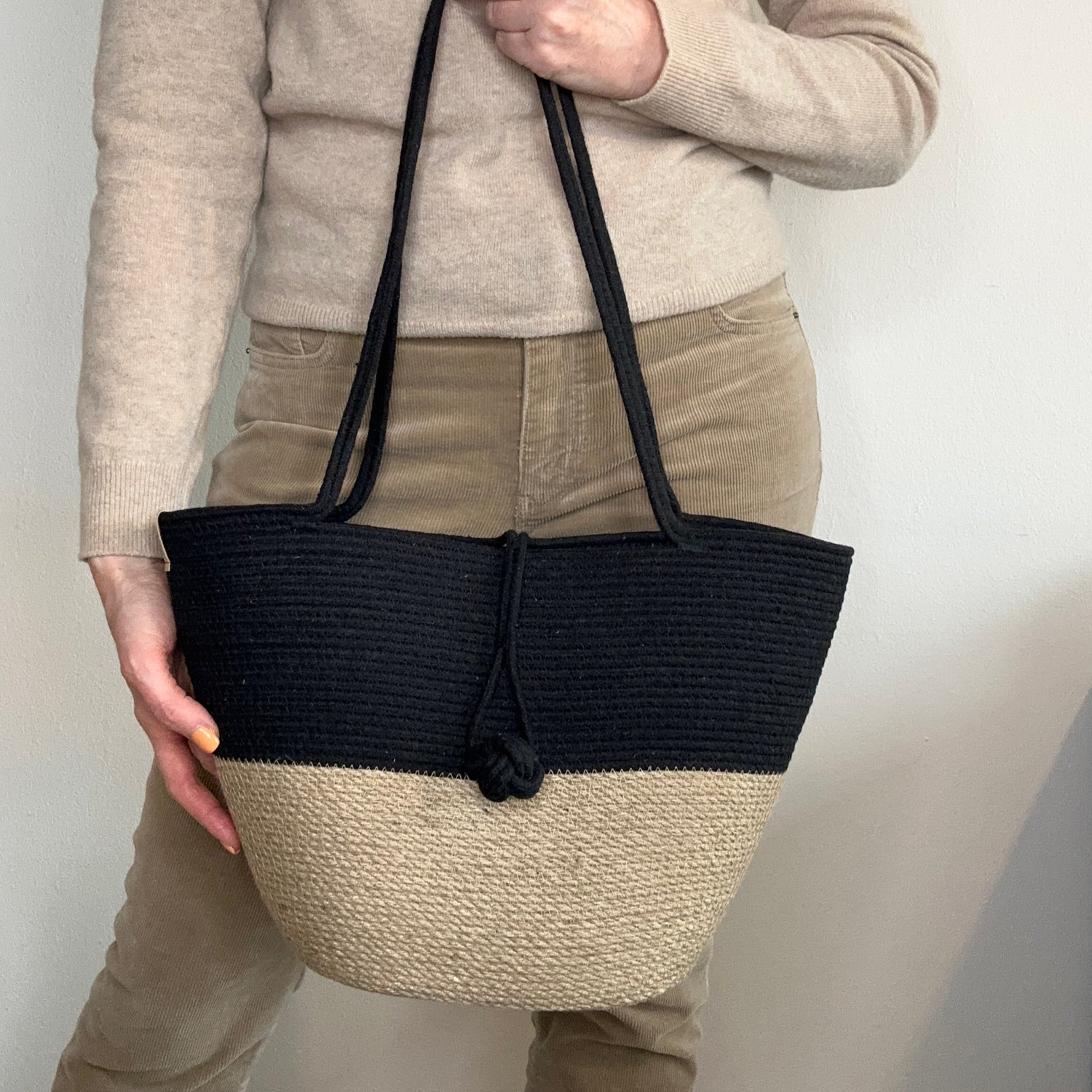 Stilfuld taske af jute og sort bomuldssnor med lange hanke og dekorativ lukning. Kvalitets håndværk.