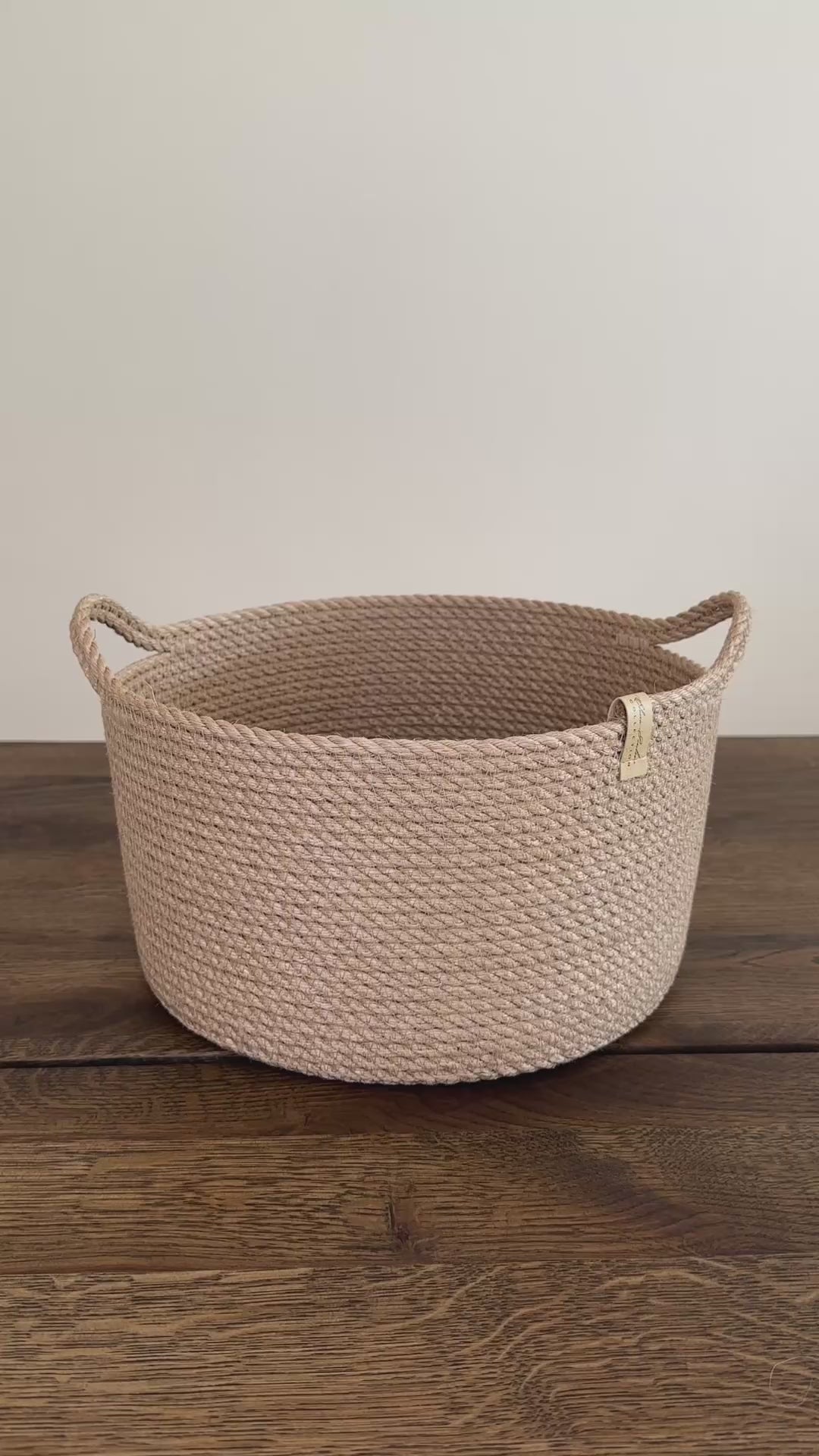 Cylinderformet jute kurv, 25 cm i diameter og 15 cm i højden, med praktiske håndtag. Det omhyggelige håndværk og premium jute fremhæver den høje kvalitet og holdbarhed.